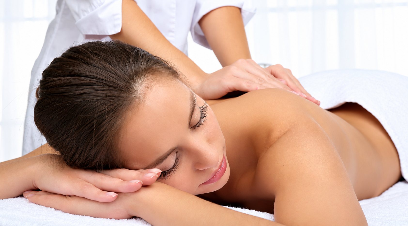 Femme allongée recevant un massage du dos dans un spa.