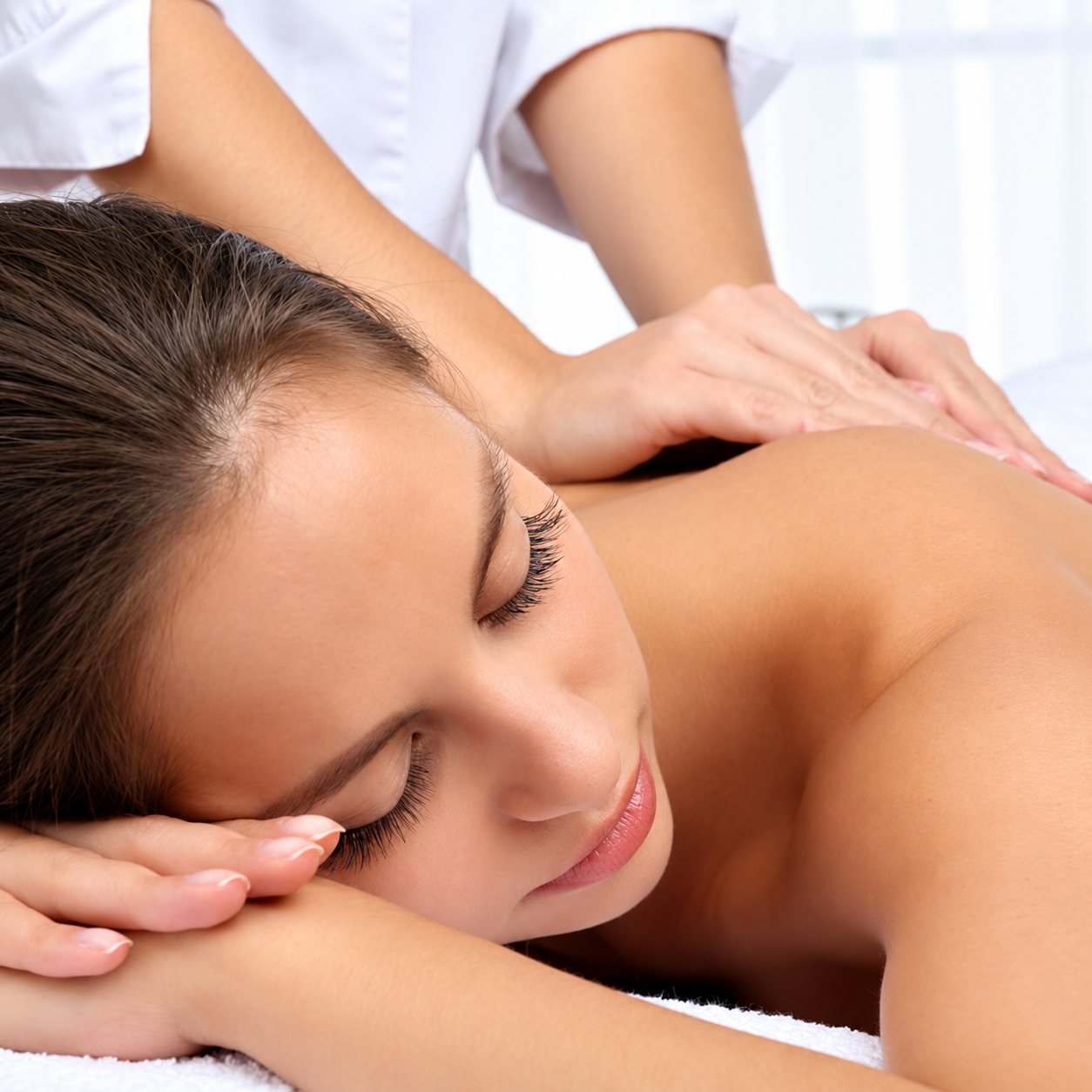 Femme allongée recevant un massage du dos.