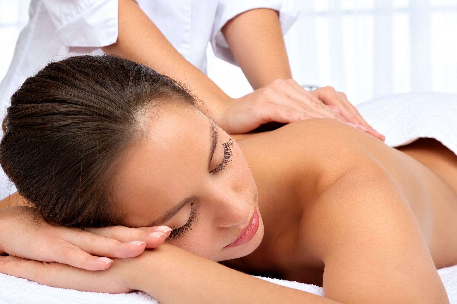 Femme allongée sur le ventre recevant un massage du dos.