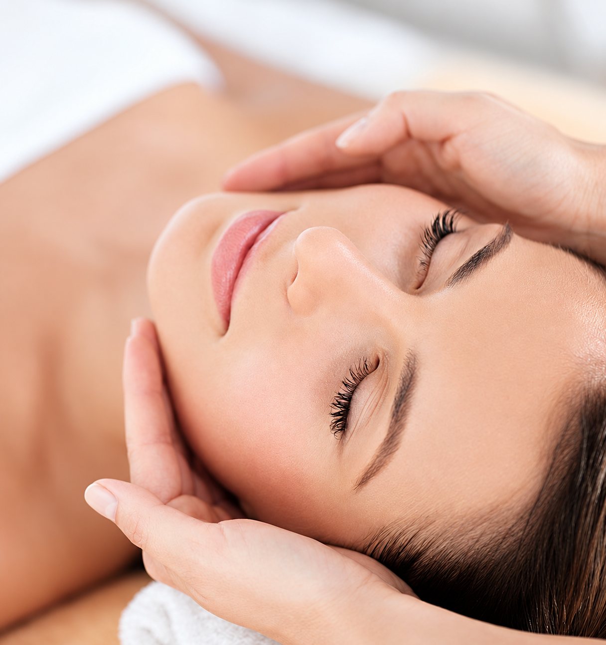 Femme recevant un massage du visage dans un institut de beauté.
